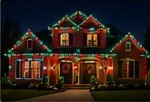Red and green holiday lighting with landscaping